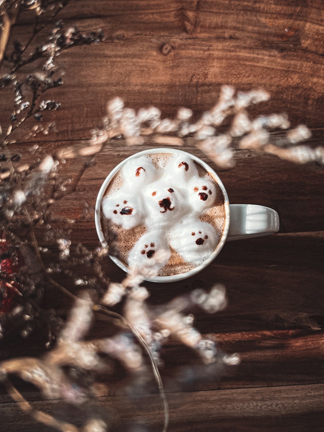 Latte with bear art sits on a rustic wooden table.
